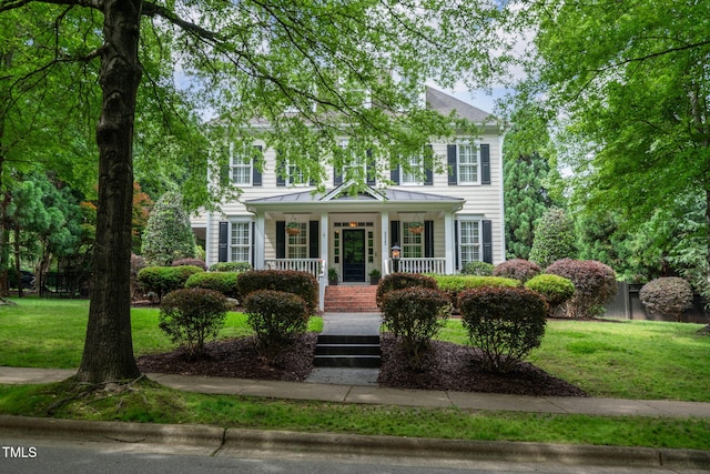 3325 Falls River Ave, Raleigh, NC 27614 - colonial inspired home featuring a porch, a front lawn, a standing seam roof, and metal roof