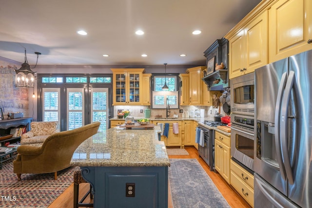 3325 Falls River Ave, Raleigh, NC 27614 - kitchen with stainless steel appliances, a center island, recessed lighting, decorative backsplash, and a sink
