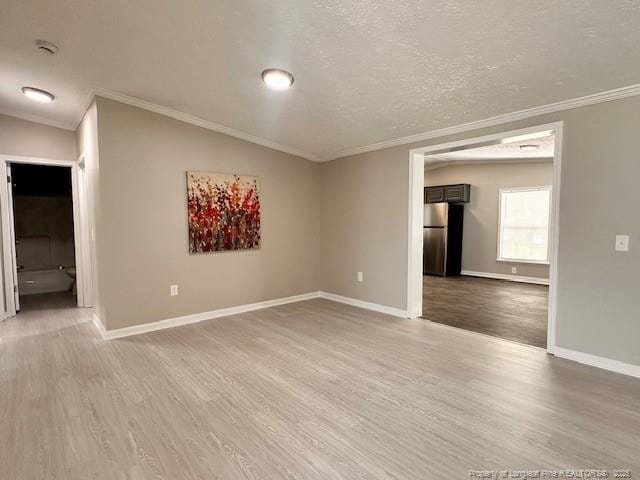unfurnished room featuring crown molding, wood finished floors, baseboards, a textured ceiling, and a smoke detector