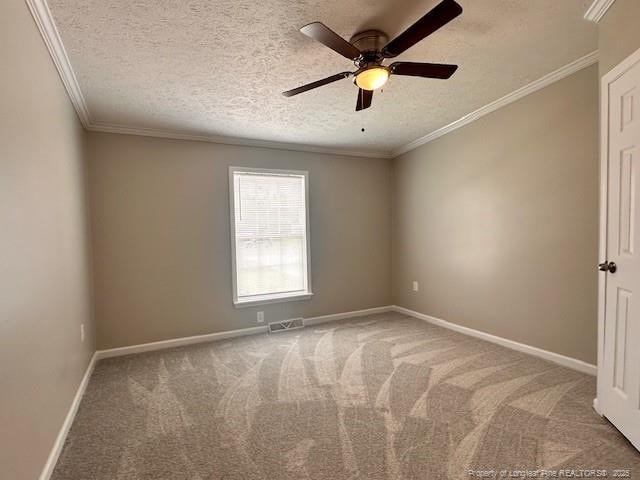 spare room featuring carpet floors, crown molding, a ceiling fan, baseboards, and a textured ceiling