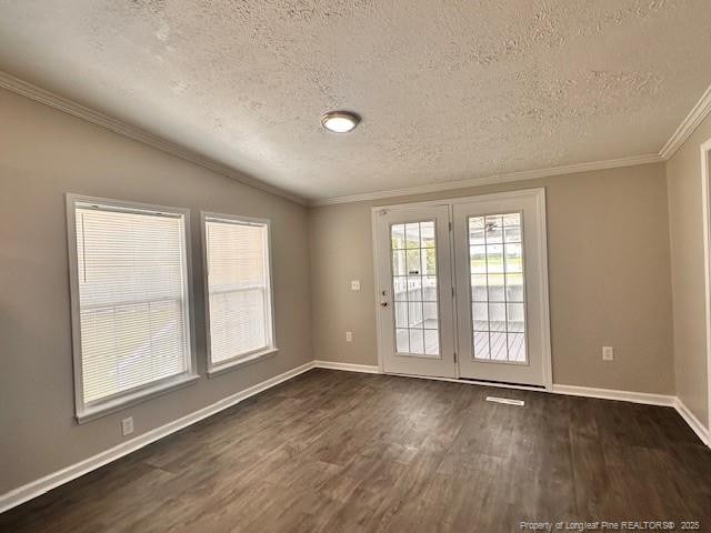 unfurnished room featuring a textured ceiling, dark wood finished floors, vaulted ceiling, baseboards, and ornamental molding