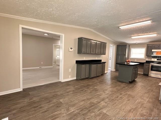 kitchen with stainless steel range with electric stovetop, a textured ceiling, ornamental molding, dark countertops, and dark wood-style floors