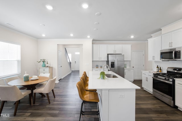 1007 Sora Way, Durham, NC 27703 - kitchen featuring stainless steel appliances, a sink, ornamental molding, a center island with sink, and light countertops