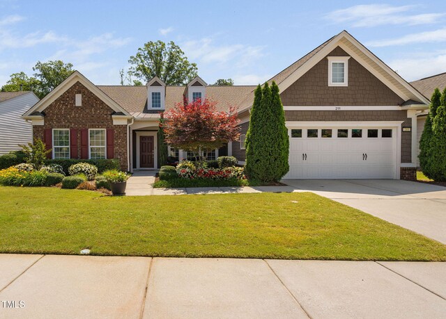 211 Ibis Ln, Durham, NC 27703 - view of front facade featuring concrete driveway, a front lawn, a garage, and brick siding