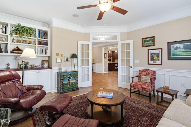 211 Ibis Ln, Durham, NC 27703 - living area with french doors, light wood-type flooring, ceiling fan, crown molding, and a wainscoted wall
