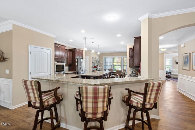 211 Ibis Ln, Durham, NC 27703 - kitchen with stainless steel appliances, ornamental molding, arched walkways, a breakfast bar, and recessed lighting