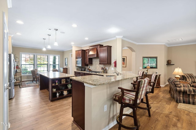 211 Ibis Ln, Durham, NC 27703 - kitchen featuring arched walkways, premium range hood, appliances with stainless steel finishes, a center island, and crown molding