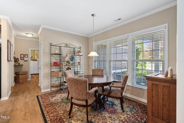 211 Ibis Ln, Durham, NC 27703 - dining area featuring light wood-style flooring, crown molding, and baseboards