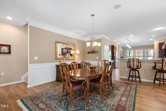 211 Ibis Ln, Durham, NC 27703 - dining space with ornamental molding, a chandelier, light wood finished floors, a wainscoted wall, and recessed lighting