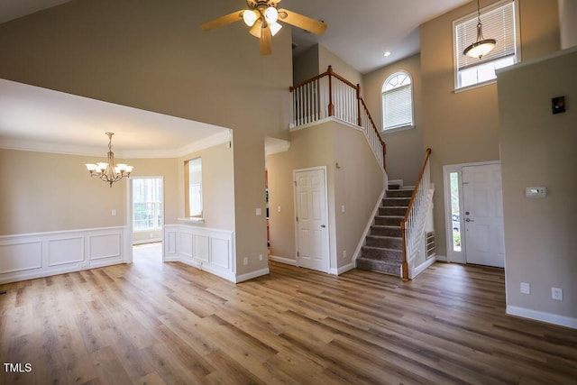 10 London Way, Spring Lake, NC 28390 - unfurnished living room with a chandelier, stairs, a towering ceiling, ceiling fan, and wood finished floors