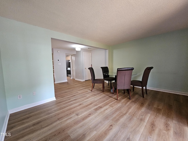 7719 Kingsberry Ct, Raleigh, NC 27615 - dining area with wood finished floors, a textured ceiling, and baseboards