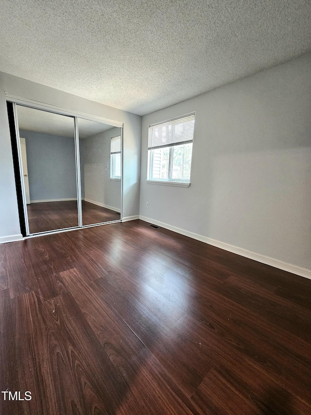 7719 Kingsberry Ct, Raleigh, NC 27615 - unfurnished bedroom with wood finished floors, a closet, a textured ceiling, and baseboards