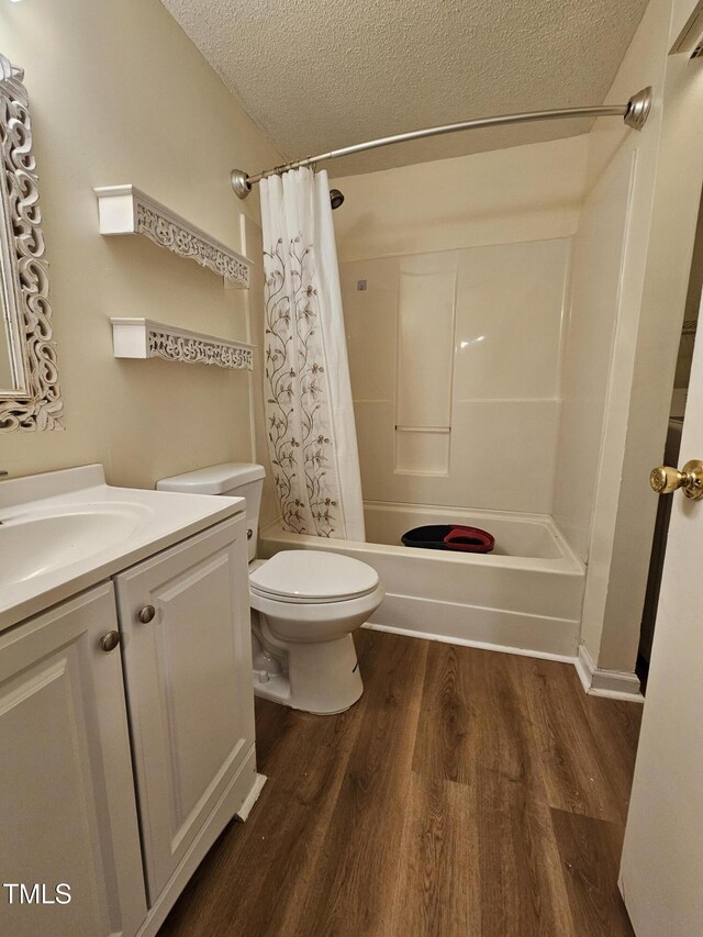 7719 Kingsberry Ct, Raleigh, NC 27615 - bathroom featuring a textured ceiling, wood finished floors, shower / bathtub combination with curtain, toilet, and vanity