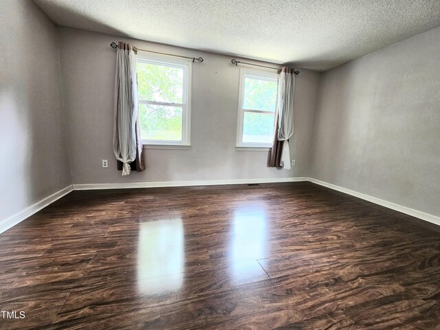 7719 Kingsberry Ct, Raleigh, NC 27615 - unfurnished room featuring a textured ceiling, dark wood-style flooring, and baseboards