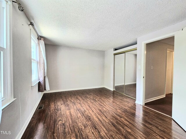 7719 Kingsberry Ct, Raleigh, NC 27615 - unfurnished bedroom with wood finished floors, a textured ceiling, a closet, and baseboards