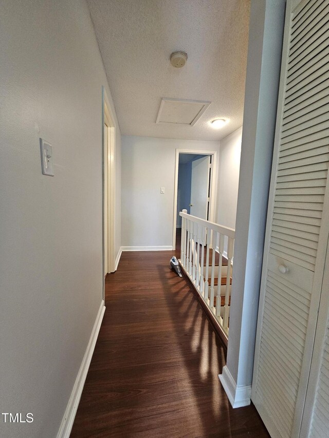 7719 Kingsberry Ct, Raleigh, NC 27615 - hallway with wood finished floors, a textured ceiling, baseboards, and an upstairs landing