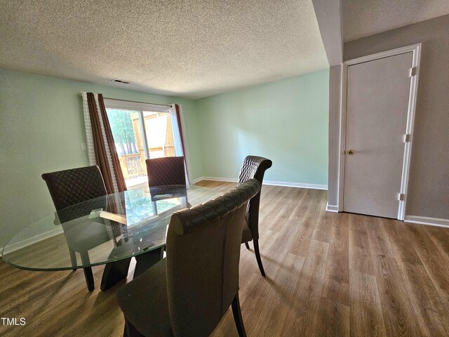 7719 Kingsberry Ct, Raleigh, NC 27615 - dining space featuring wood finished floors, a textured ceiling, and baseboards