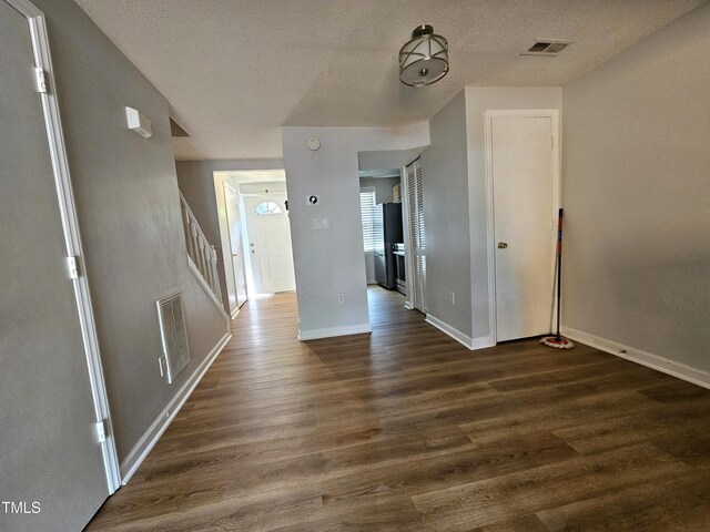 7719 Kingsberry Ct, Raleigh, NC 27615 - spare room featuring dark wood-style floors, baseboards, stairs, and a textured ceiling