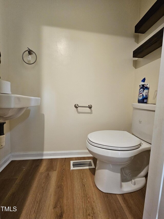 7719 Kingsberry Ct, Raleigh, NC 27615 - half bathroom with wood finished floors, toilet, and baseboards