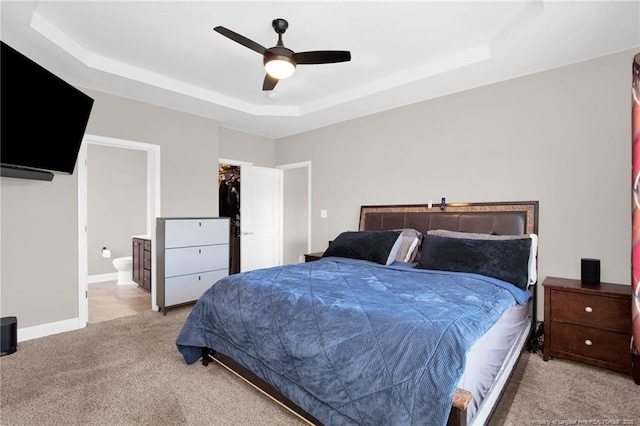 341 Woodington Rd, Hope Mills, NC 28348 - bedroom with a raised ceiling, light colored carpet, ensuite bath, a ceiling fan, and a walk in closet
