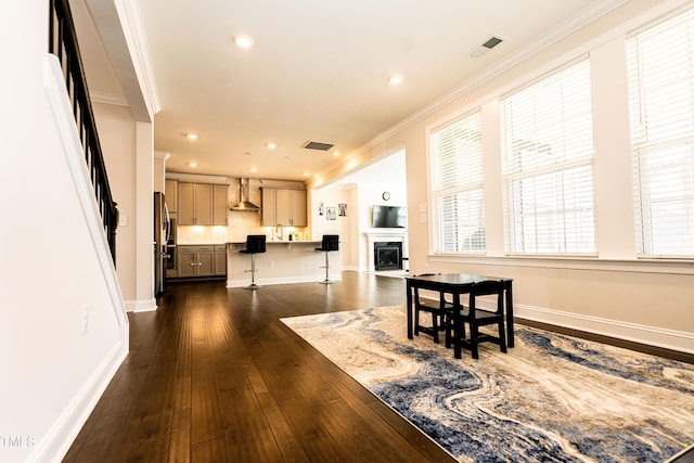 2918 Heirloom Way, Apex, NC 27502 - dining room featuring ornamental molding, dark wood-style flooring, a glass covered fireplace, recessed lighting, and baseboards
