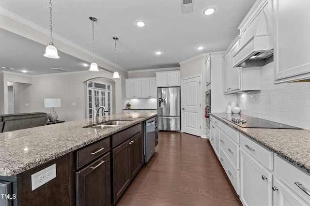 1112 Monterey Bay Dr, Wake Forest, NC 27587 - kitchen featuring a sink, stainless steel appliances, arched walkways, custom range hood, and dark brown cabinets