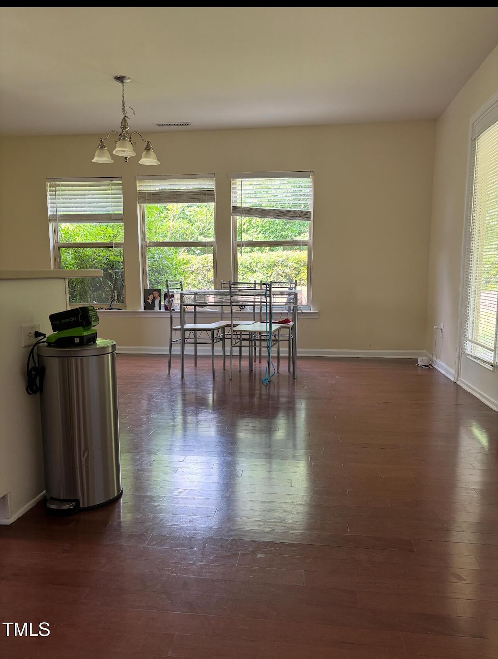 dining area featuring dark wood-style flooring, baseboards, and a chandelier