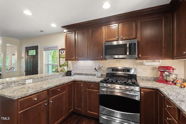 3002 Bartlett Cir, Hillsborough, NC 27278 - kitchen with appliances with stainless steel finishes, a peninsula, decorative backsplash, light stone counters, and recessed lighting