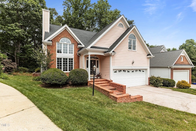 traditional-style home with driveway, a front lawn, a chimney, and brick siding