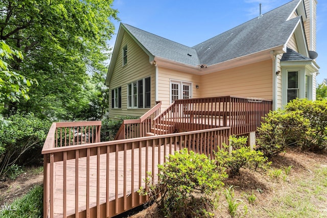 back of property with roof with shingles and a wooden deck