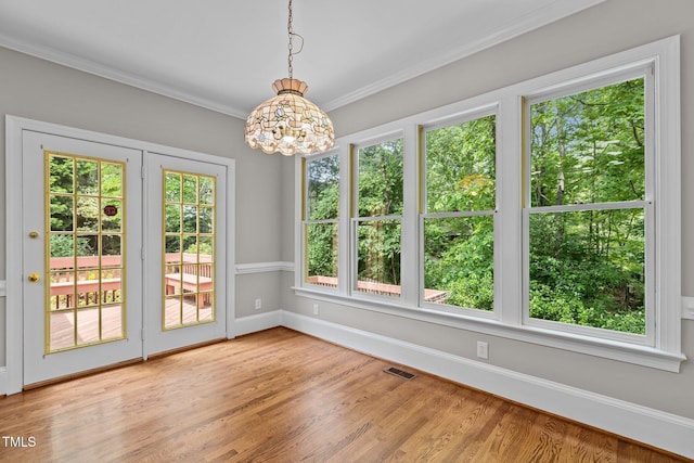 unfurnished sunroom with plenty of natural light, a chandelier, and french doors
