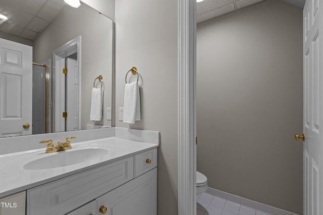 full bathroom featuring a paneled ceiling, tile patterned floors, toilet, vanity, and an enclosed shower