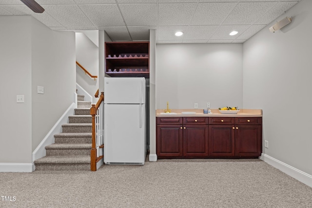 kitchen with freestanding refrigerator, light colored carpet, a drop ceiling, baseboards, and recessed lighting