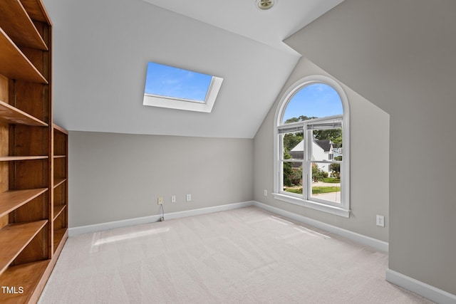 bonus room featuring a skylight, vaulted ceiling, carpet flooring, and baseboards
