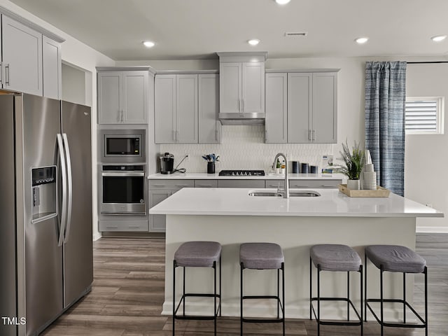 2242 Cherry Creek Rd, Haw River, NC 27258 - kitchen with appliances with stainless steel finishes, a sink, a breakfast bar, under cabinet range hood, and light countertops