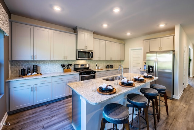 2250 Cherry Creek Rd, Haw River, NC 27258 - kitchen with appliances with stainless steel finishes, a sink, dark wood finished floors, a kitchen bar, and light stone counters