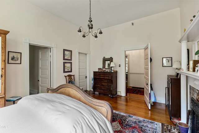 517 N E St, Raleigh, NC 27604 - bedroom with wood finished floors, a fireplace, a towering ceiling, a chandelier, and baseboards