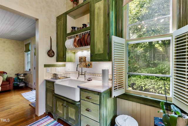 517 N E St, Raleigh, NC 27604 - kitchen with green cabinets, a sink, hardwood / wood-style floors, light countertops, and backsplash