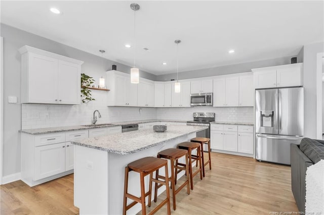 607 Rempstone Ln, Fayetteville, NC 28311 - kitchen with appliances with stainless steel finishes, a sink, white cabinetry, a center island, and recessed lighting
