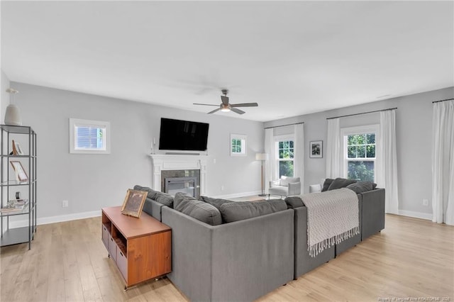607 Rempstone Ln, Fayetteville, NC 28311 - living room with ceiling fan, light wood-style flooring, a glass covered fireplace, and baseboards