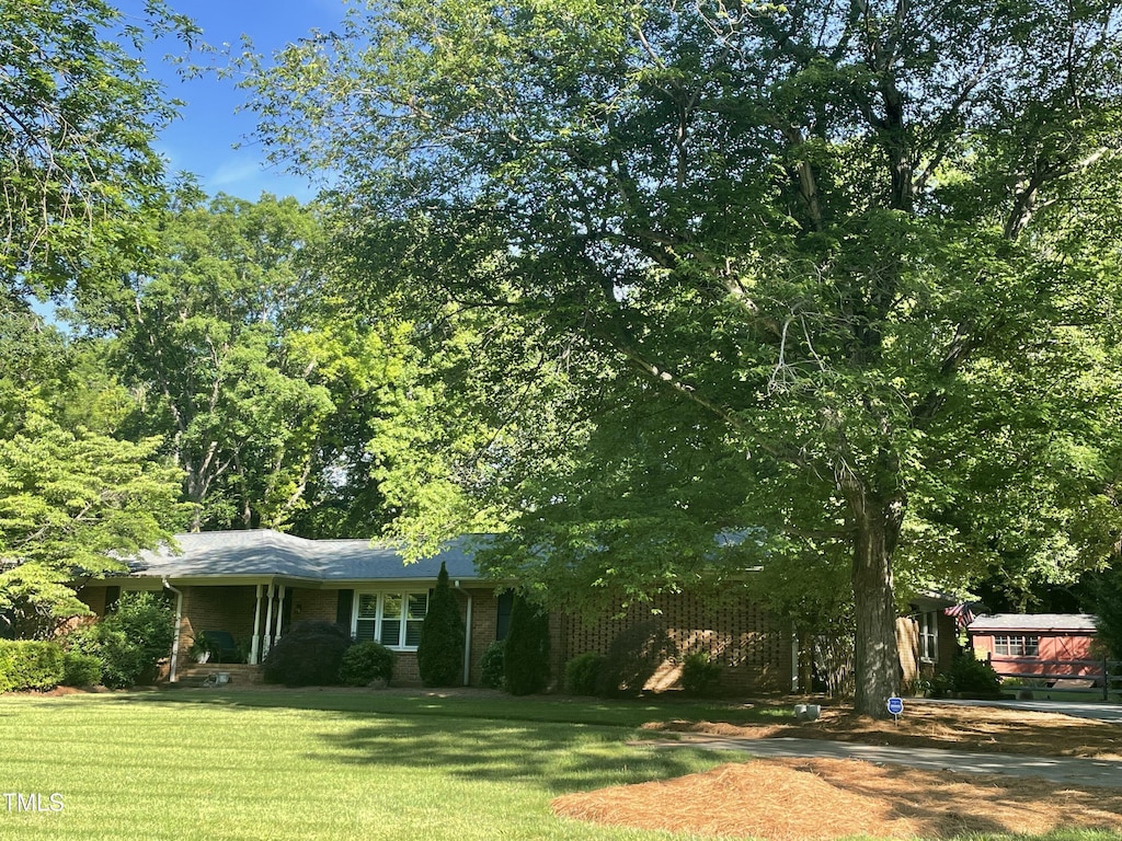 view of front of home featuring a front lawn and brick siding