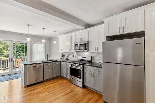 1304 N Duke St, Durham, NC 27701 - kitchen with stainless steel appliances, dark countertops, a sink, a peninsula, and backsplash