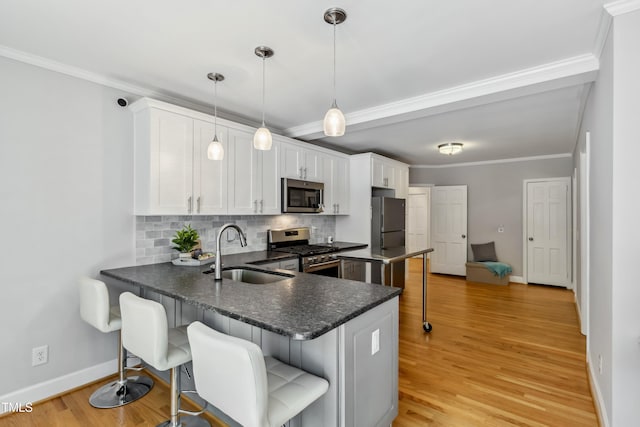 1304 N Duke St, Durham, NC 27701 - kitchen featuring appliances with stainless steel finishes, a sink, a peninsula, baseboards, and backsplash