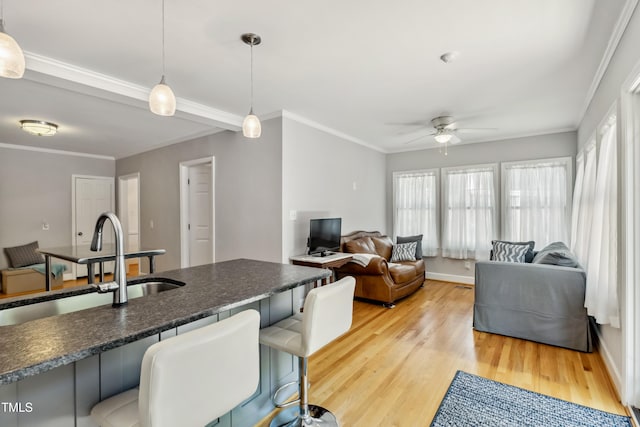 1304 N Duke St, Durham, NC 27701 - kitchen with a ceiling fan, light wood-type flooring, dark countertops, decorative light fixtures, and crown molding