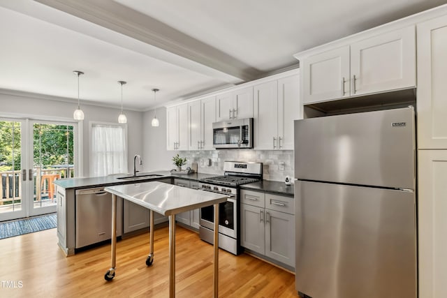 1304 N Duke St, Durham, NC 27701 - kitchen featuring stainless steel appliances, a sink, dark countertops, a peninsula, and backsplash