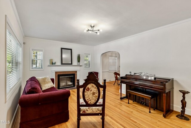 1304 N Duke St, Durham, NC 27701 - living area with arched walkways, a brick fireplace, crown molding, baseboards, and light wood-type flooring