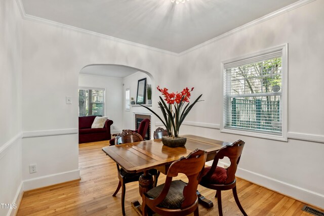 1304 N Duke St, Durham, NC 27701 - dining room with healthy amount of natural light, arched walkways, crown molding, light wood-type flooring, and baseboards