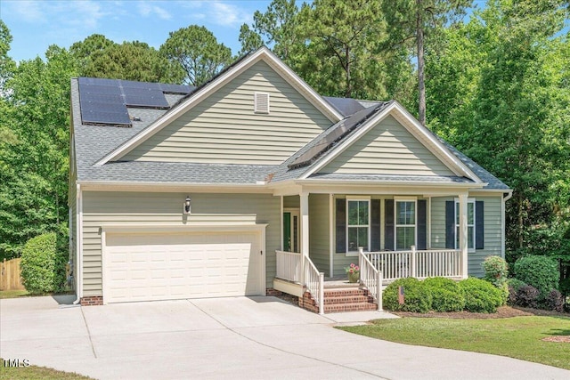 6512 Blalock Forest Dr, Willow Springs, NC 27592 - view of front of house with covered porch, concrete driveway, an attached garage, solar panels, and a shingled roof