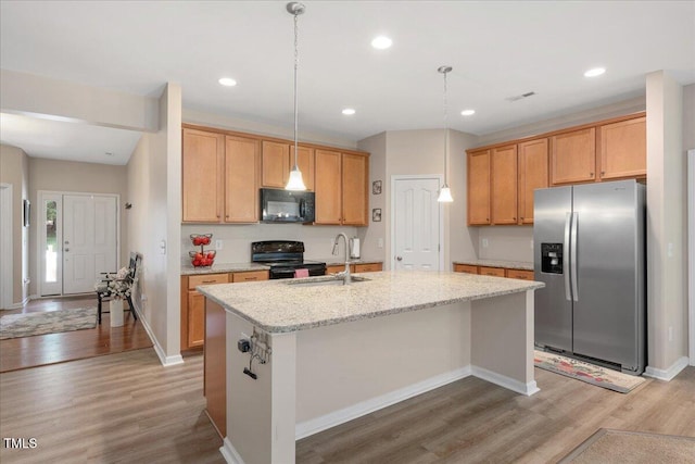6512 Blalock Forest Dr, Willow Springs, NC 27592 - kitchen featuring black appliances, light wood-style floors, a kitchen island with sink, light stone counters, and hanging light fixtures