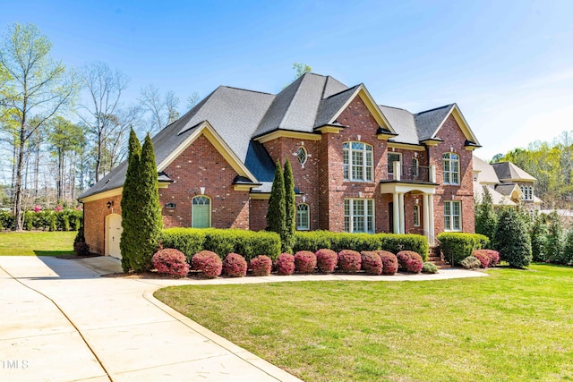 3908 Chaumont Dr, Apex, NC 27539 - georgian-style home with brick siding, a front yard, concrete driveway, and roof with shingles